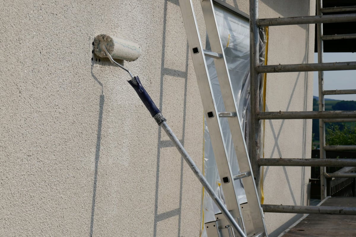 Painting walls with roller staircase scaffolding
