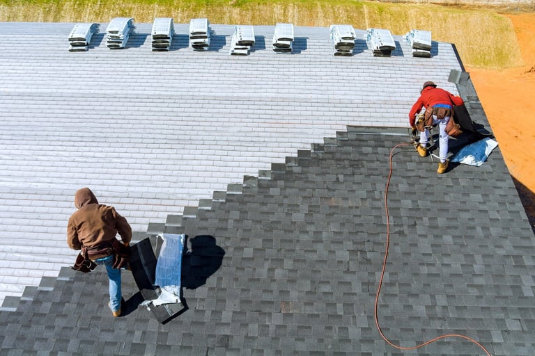 Aerial view of worker installing roof shingles