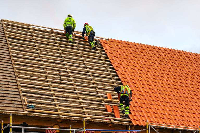 Roofers installing clay tiles