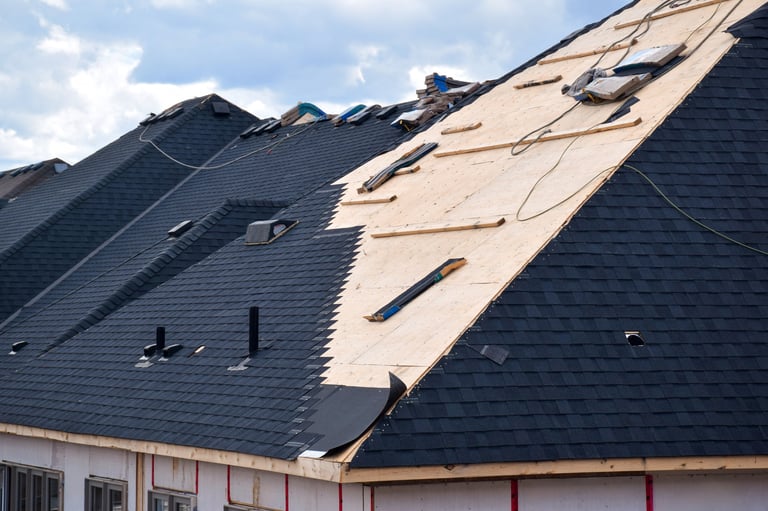 Closeup installation of black roof shingles