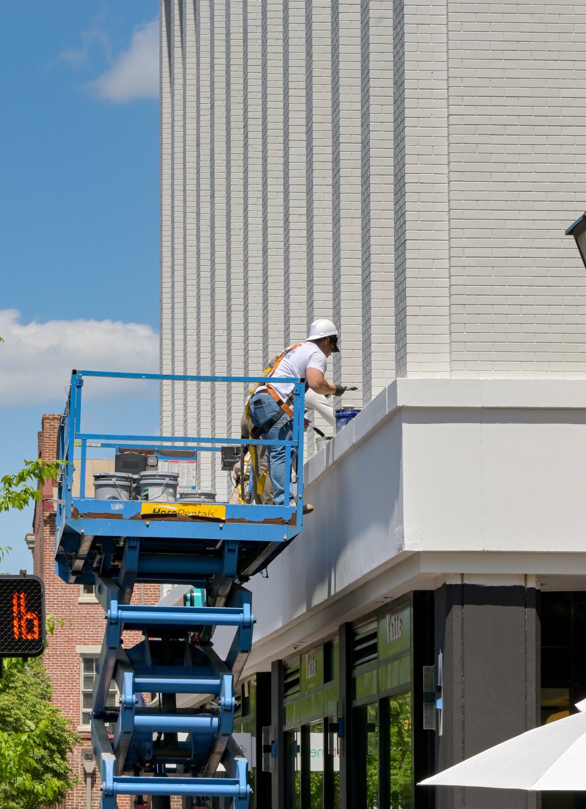 People on hydraulic scissor lift doing maintenance work on building