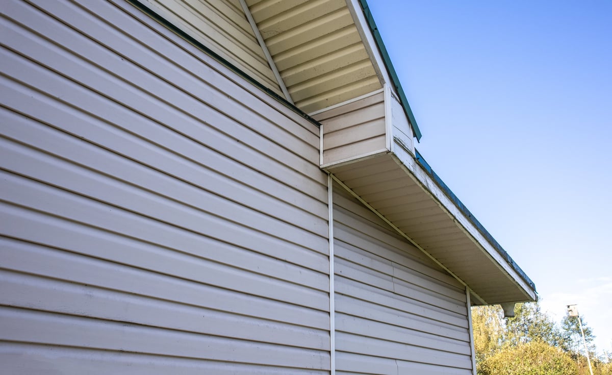 Private house facade with vinyl siding and roof overhang