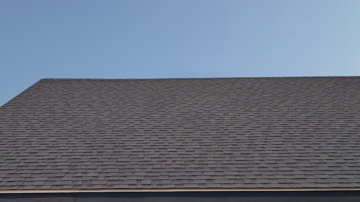 Detailed view of residential roof with dark grey asphalt shingles